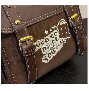 Detailed close-up of brown faux leather and suede patchwork with nice to meet you embroidery