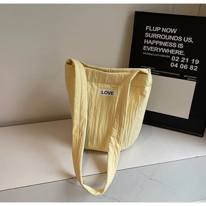 Detailed view of quilted bucket bag with vertical stitching and LOVE fabric label