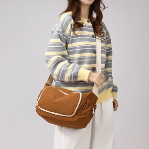 Detail view of brown nylon crossbody bag with contrast trim and adjustable strap