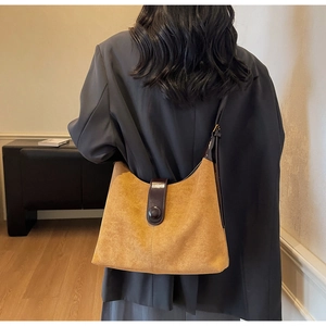 Detail of vintage mustard suede tote bag with brown leather strap and round buckle