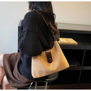 Detail view of khaki suede crescent bag with dark brown leather strap and buckle closure