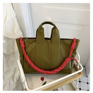 Dettaglio ravvicinato della borsa tote in PU verde oliva con corda intrecciata rossa a contrasto