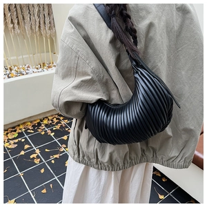 Close-up of black pleated hobo bag texture and elegant vertical striped design details