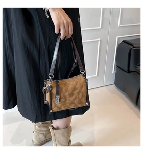 Detail of vintage quilted handbag with brown suede texture and silver metallic rivets