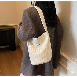 White pleated shoulder bag with LOVE label shown in a lifestyle interior setting