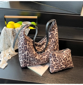 Detailed shot of leopard print large hobo bag and matching zip pouch on wooden steps