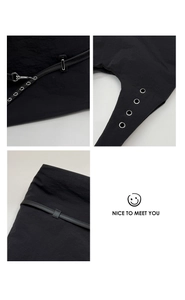 Detailed macro view showing the metallic grommets and straps on this black tote bag
