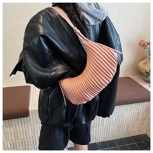 Detail of pink pleated crescent bag with high-quality texture and leather shoulder strap