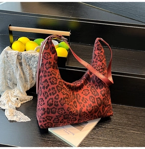 Detail of red leopard print hobo bag with soft suede texture and stylish zipper closure
