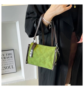 Fashionable green quilted handbag with brown straps and silver studs in street style