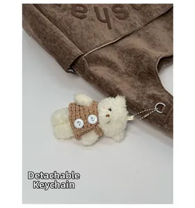 Détail du pendentif ours amovible sur un sac cabas en velours côtelé marron avec anneau