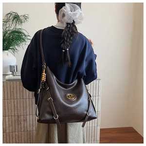 Sac hobo en cuir marron foncé avec logo M en métal et pendentif sur mannequin