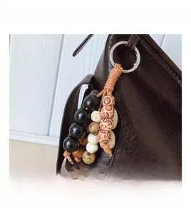 Nahaufnahme des Vintage-Perlenanhängers mit Silberring an brauner Ledertasche