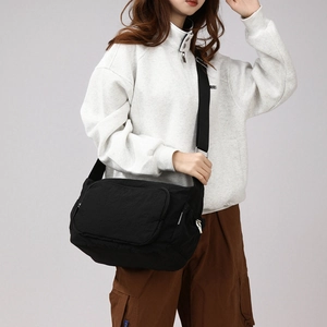 Detail view of large nylon crossbody bag showing the adjustable strap and silver metal buckle