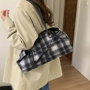 Detail of black and white plaid tote bag in tweed fabric with adjustable drawstrings