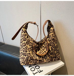 Detail of leopard print hobo bag with adjustable brown leather strap and metal buckle