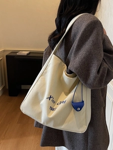 Borsa tote in tela color crema con scritte blu Xiao Quai 1987 e ciondolo laterale blu