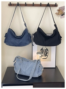 Close-up of distressed denim hobo bags with adjustable straps and side button pockets