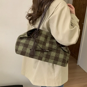 Retro green plaid tote bag with brown leather straps shown on a model side view