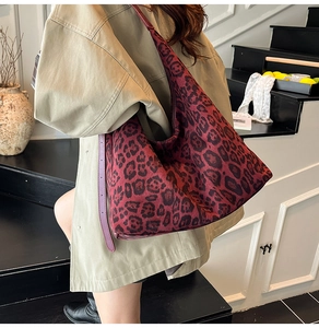Detailed side view of large burgundy leopard print tote bag with purple leather strap