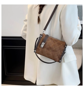 Brown quilted crossbody bag detail with silver turn-lock and metallic rivets shown on model