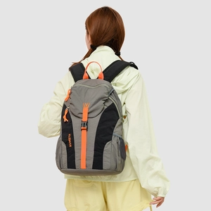 Detail of outdoor backpack featuring gray and black contrast with orange accents and buckles