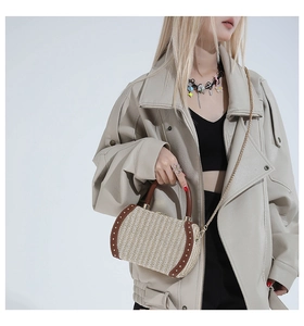 Detail view of woven box bag with brown leather trim and metallic rivet accents