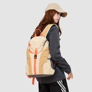 Detail view of lightweight travel backpack with orange straps and side mesh pocket
