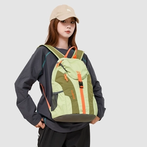Detail showing the green color-block nylon fabric and orange carry handle of the travel bag