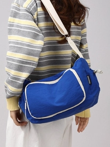 Blue large capacity nylon crossbody bag with wide strap worn by model on back
