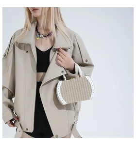 Detail of vintage woven handbag paired with oversized beige leather biker jacket
