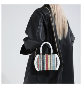 Macro detail of rainbow woven texture handbag with gold rivets and white handles