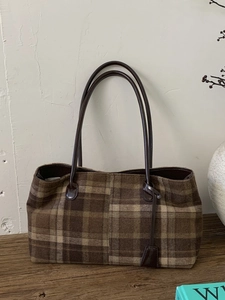 Retro brown plaid woolen tote bag for women with leather handles on a wooden table