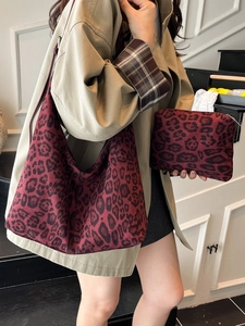 Burgundy leopard print canvas tote bag and matching pouch shown on shoulder