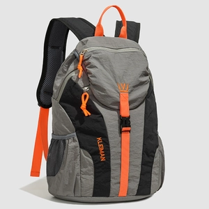 Detail of grey nylon backpack with vibrant orange straps and side mesh pocket view
