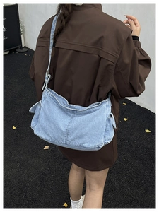 Detail of light blue denim hobo bag featuring side pocket and adjustable strap