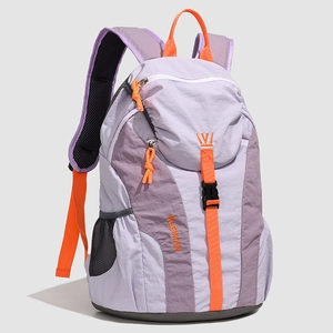 Detail view of purple nylon travel backpack showing orange zipper pulls and side mesh pocket