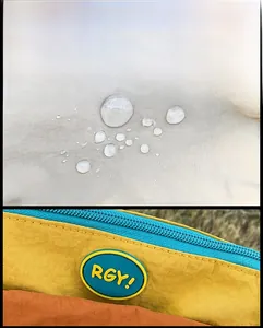 Dettaglio del tessuto in nylon impermeabile con cerniera blu e toppa rotonda del logo