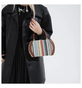 Close-up of rainbow woven handbag with brown leather handle and metal rivet details