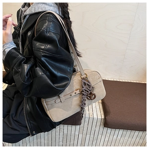 Detail view of cream vintage shoulder bag with textured leather and adjustable strap