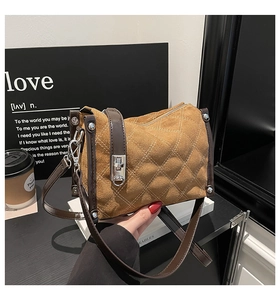 Detail of tan quilted suede handbag with silver twist lock and dark brown leather trim