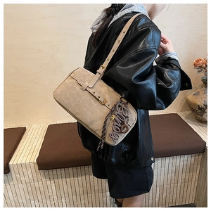 Chic beige retro shoulder bag with metallic letter charm and adjustable strap detail