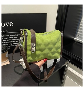 Close-up of bright green quilted suede handbag with silver twist lock and brown straps