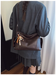Details einer braunen Vintage-Umhängetasche aus PU-Leder mit bunter Perlenquaste