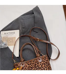 Détail du sac à main léopard montrant les bandoulières lisses et les coutures précises