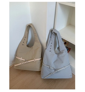 Detail of minimalist nylon tote bags with metallic eyelets and adjustable leather straps