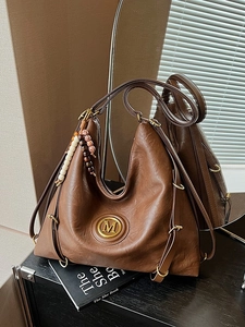 Sac hobo vintage marron avec logo en métal doré et accessoire de charme en perles