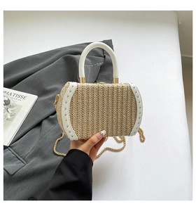 Close-up of beige woven basket bag featuring white leather trim and gold metal studs