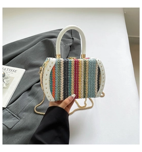 Detail of colorful woven handbag featuring gold chain strap and elegant rivet handle