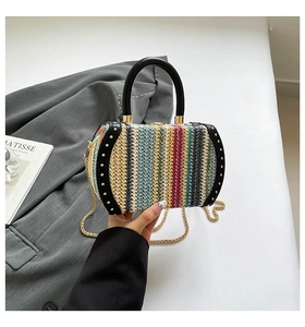 Detail of multi-color woven handbag with gold rivets, black handle and chain strap